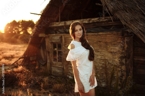 woman in a white dress at sunset on the nature. portrait of a beautiful girl