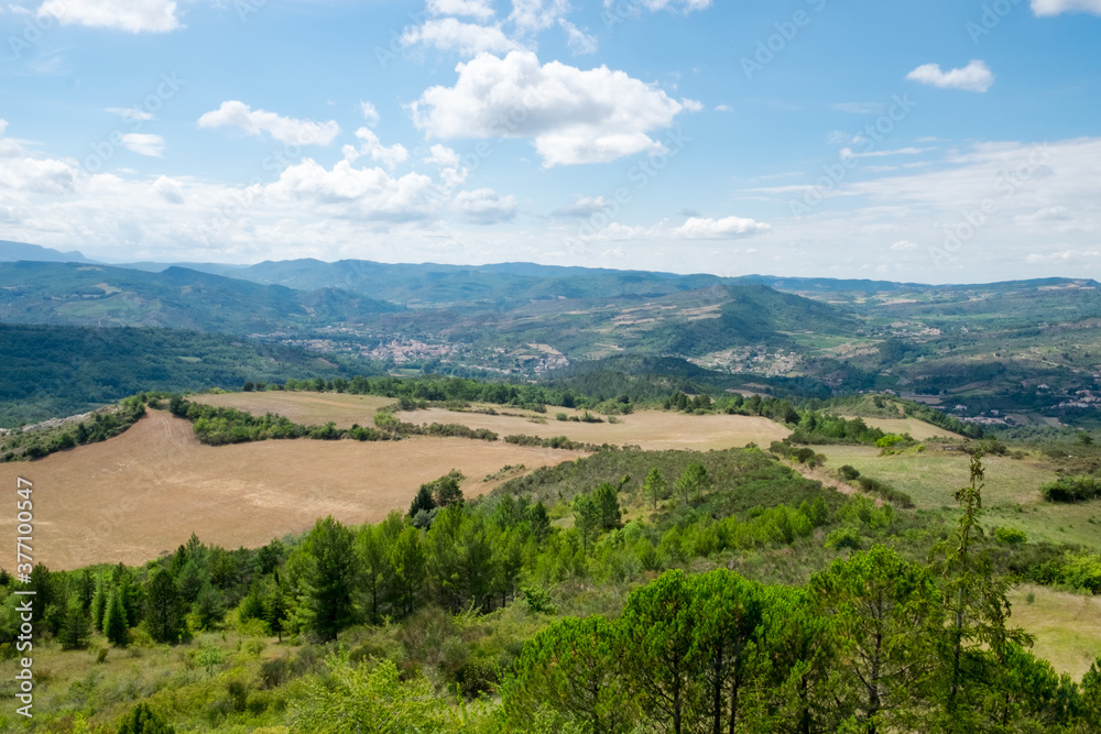 The panoramic view of the magnificent green montain valley with alpine meadow, emerald forest and Pyrenees peaks in the French countryside near the medieval village Rennes le Chateau in France