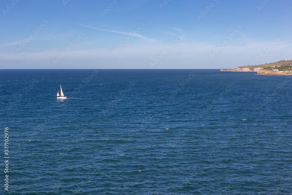 A boat sailing away from the coast