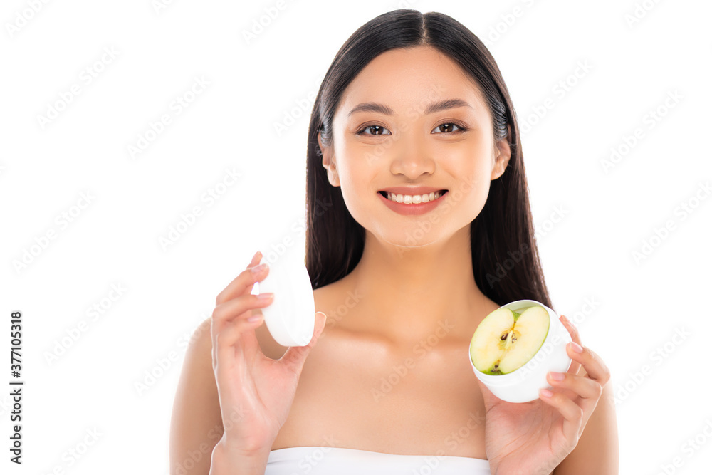 brunette asian woman holding container of cosmetic cream with half of apple isolated on white brunette asian woman holding container of cosmetic cream with half of apple isolated on white