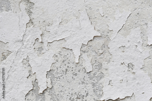 Peeling paint of white wall.Closeup of peeling painted wall.Grungy cracked white wall paint peeling off.