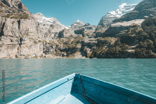 Summer alpine landscape on the Oeschinensee (Oeschinen lake) from a small boat, in the Swiss Alps near Kandersteg in the Bernese Oberland.