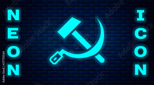 Glowing neon Hammer and sickle USSR icon isolated on brick wall background. Symbol Soviet Union. Vector.