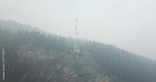 aerial drone shot of the cliff side of Bastion Mountain with a radio tower on a smokey day caused by forest fires. photo