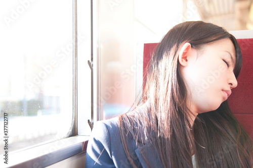 電車で居眠りする女性