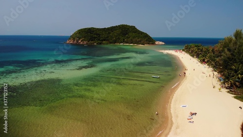 Aerial drone view small Koh Ma island, Ko Phangan Thailand. Exotic coast panoramic landscape, Mae Haad beach, summer day. Sandy path between corals. Vivid seascape, mountain coconut palms from above. © Dogora Sun