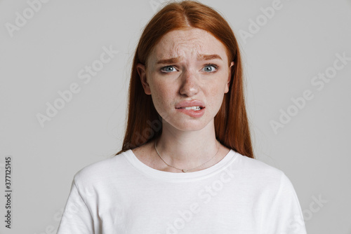 Image of unhappy ginger beautiful girl looking at camera