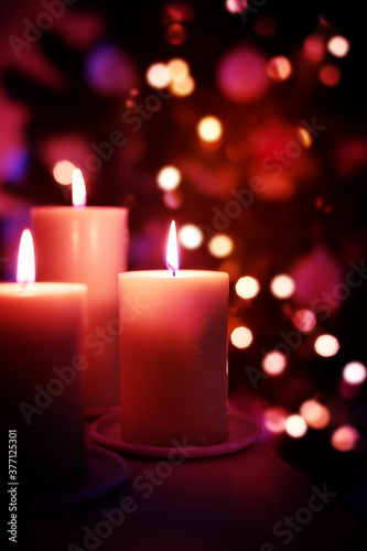 hristmas candles on garland lights blurred background, copy space