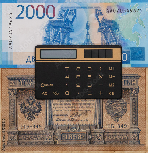 Calculator on the background of two Russian banknotes, tsarist and modern photo