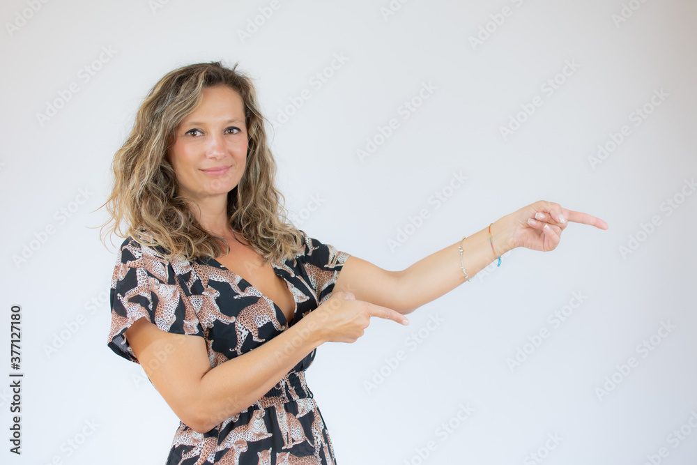Smiling beautiful woman in printed dress pointing something Smiling beautiful woman in printed dress pointing something