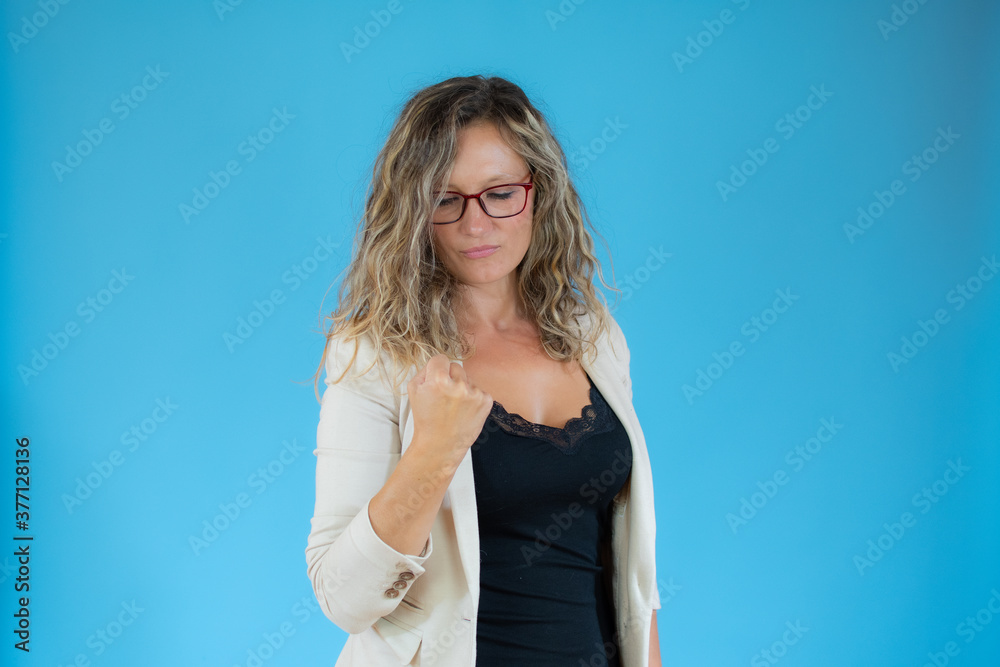 Business woman with a triumphant gesture on blue background Business woman with a triumphant gesture on blue background