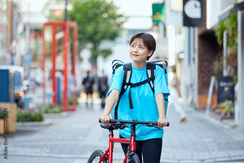 自転車でフードデリバリーを行う女性