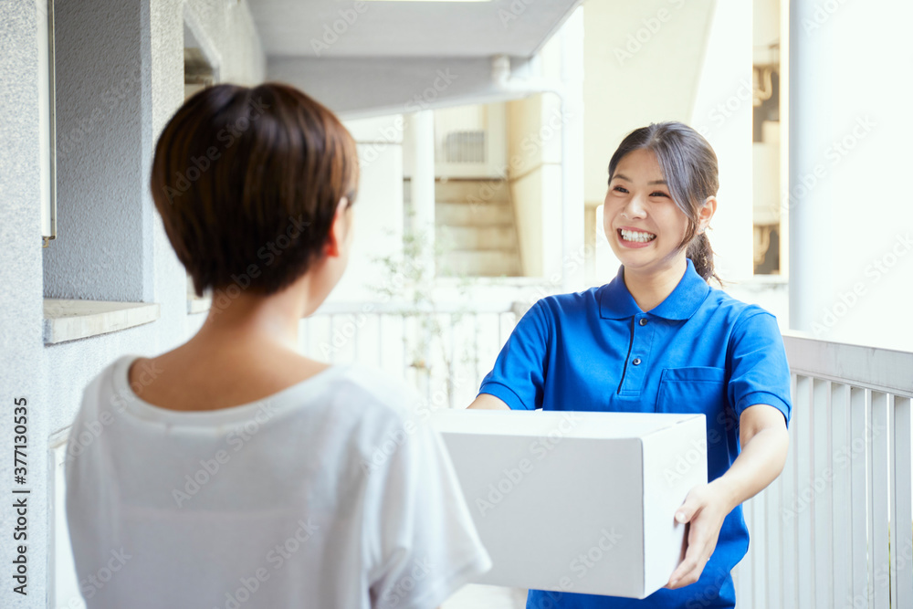 Fototapeta premium 宅配を行う若い日本人女性