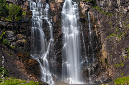 Skjervsfossen waterfall, on the road between Granvin and Voss, Hordaland, Norway. Impressive beautiful win falls plunging 150 metres in a narrow canyon photo