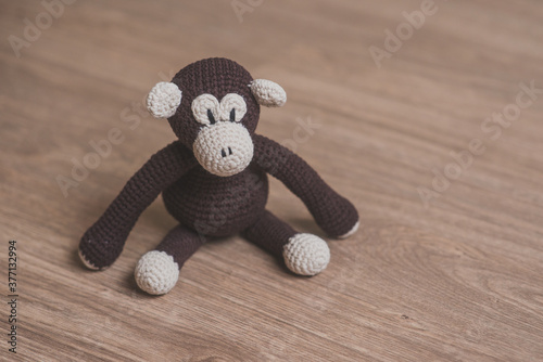 handcrafted crochet amigurumi monkey in wooden background