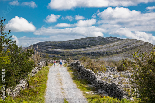 tourists walking through the Burren national park in County Clare, Ireland photo