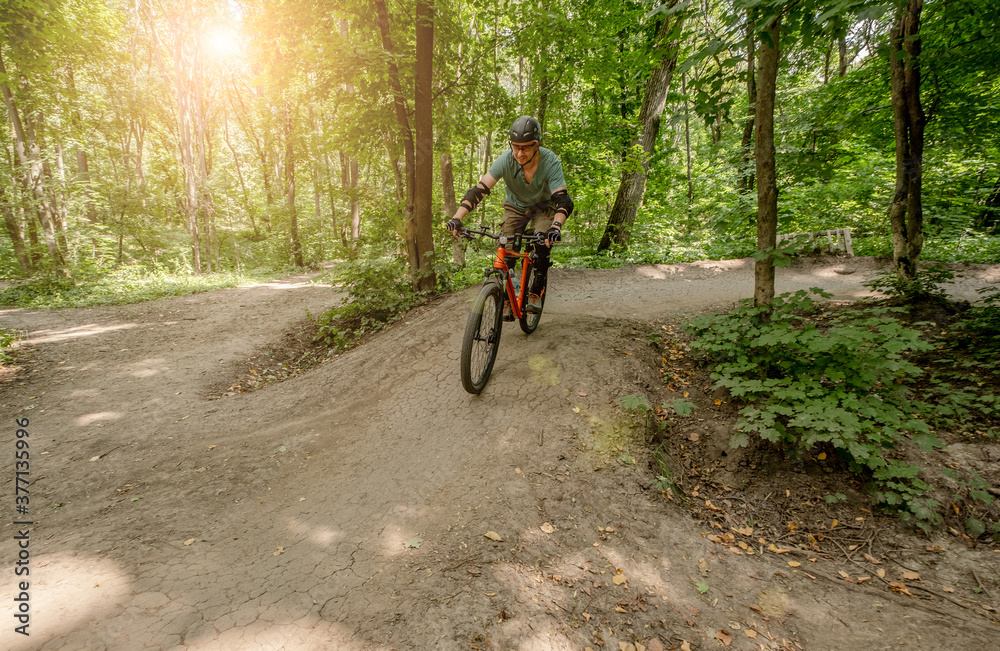 Man riding bicycle on forest road