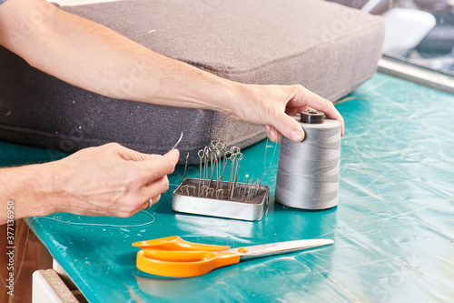 Qualified workman upholstering furniture in repair furniture