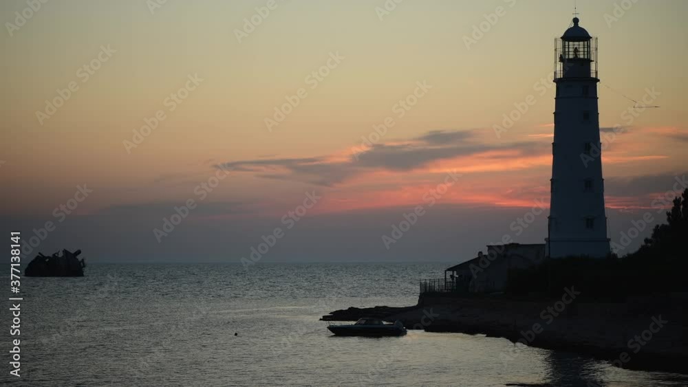 Amazing colourful time lapse sunset at ocean near old Lighthouse and sunken ship Amazing colourful time lapse sunset at ocean near old Lighthouse and sunken ship