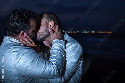 gay couple of men kissing at night