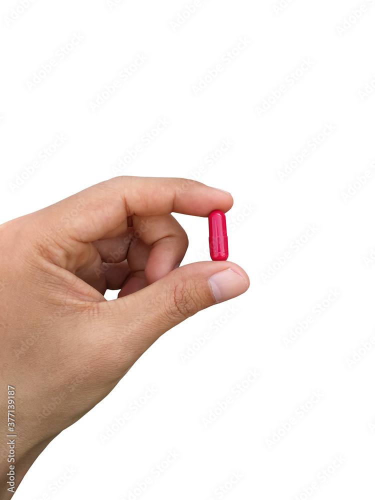 Hand holding red pill isolated on white background. Hand holding red pill isolated on white background.