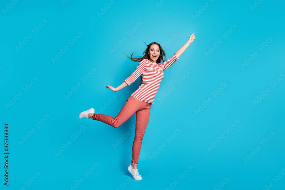 Full length photo of excited energetic girl hold hand try catch dream parasol her hairstyle wind air blow wear good look casual outfit sneakers isolated over blue color background