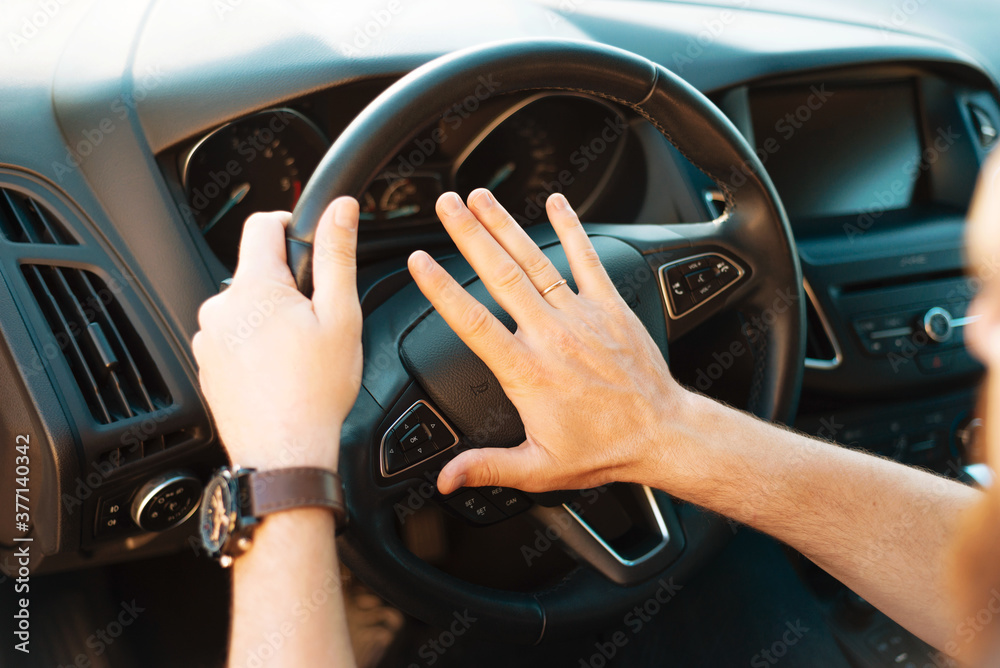 Close up photo of man honking in traffic jam, rush hour