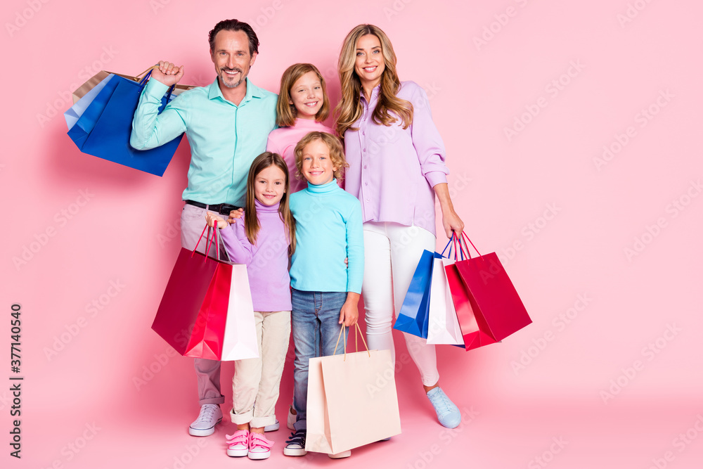 Full size photo of big full family enjoy shopping center dad daddy mom mommy three little kids buy purchase hold bags isolated over pastel pink color background Full size photo of big full family enjoy shopping center dad daddy mom mommy three little kids buy purchase hold bags isolated over pastel pink color background