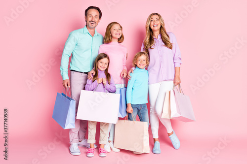 Full size photo of big full family mom mommy dad daddy little kids have free time go walk shopping center buy hold bags isolated over pastel color background