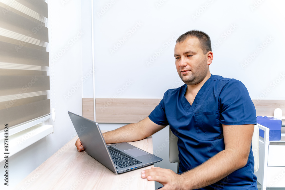 Handsome doctor having a medical consultation with patient over internet. Computer telemedecine diagnostic. Covid restrictions.