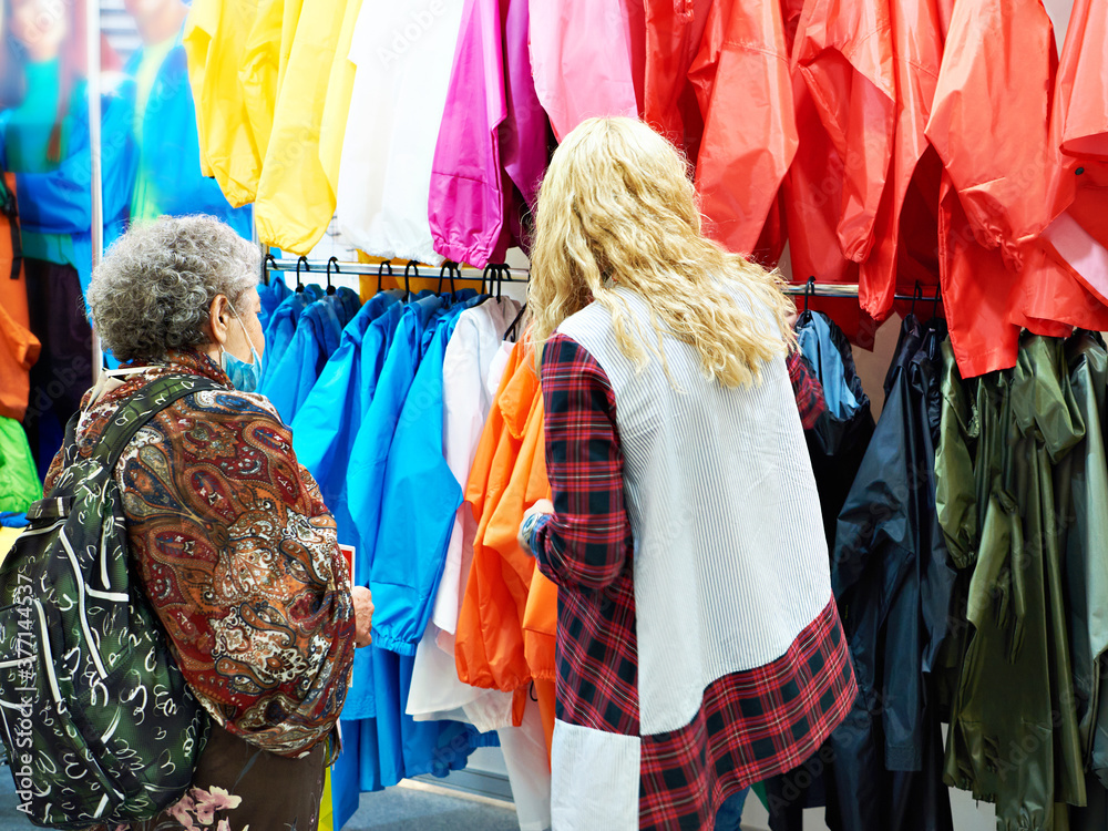 Buyers womans chooses jacket clothes in store