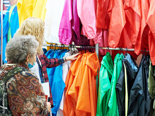Buyers womans chooses jacket clothes in store
