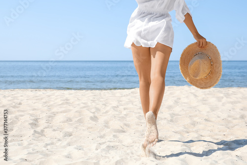 Young woman with beautiful body on beach, closeup. Space for text