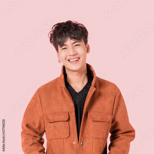 Portrait of happy asian handsome young man in fashionable clothing with standing and smiling isolated on pink background. 