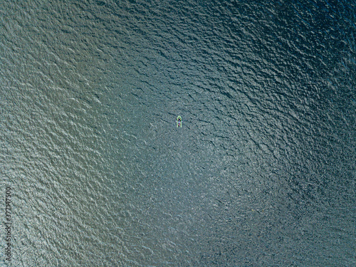 Aerial drone view. Fishing boat on the waves of the river.