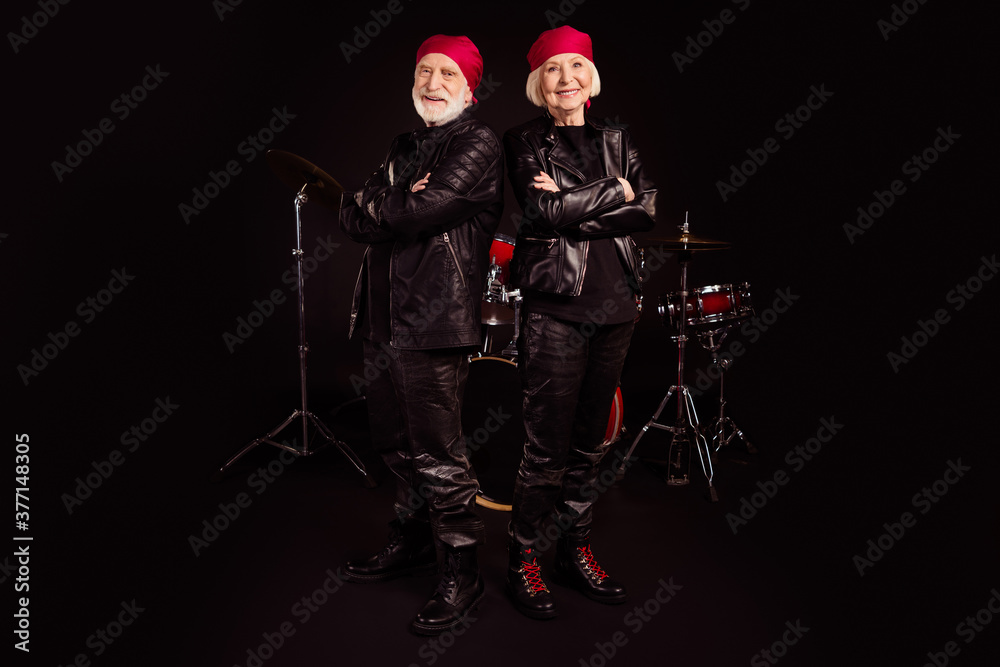 Full length photo of two pensioners family cool aged lady man rock group all life together concert show drum instruments wear trendy rocker leather outfit isolated black color background Full length photo of two pensioners family cool aged lady man rock group all life together concert show drum instruments wear trendy rocker leather outfit isolated black color background