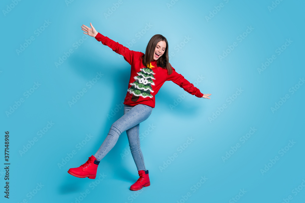 Full size photo of cool positive girl in christmas tree decor pullover jumper dance x-mas theme event isolated over blue color background