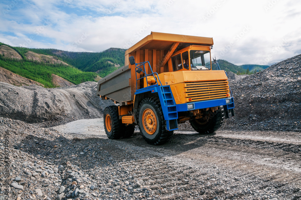 Mountainous dump truck is widely used for transporting and unloading rocks. Mining. Mountainous dump truck is widely used for transporting and unloading rocks. Mining.