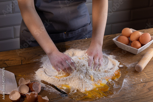 The chef's hands are kneading the dough for dumplings, pasta, bread, or pizza. Cooking dumplings – step by step guide.