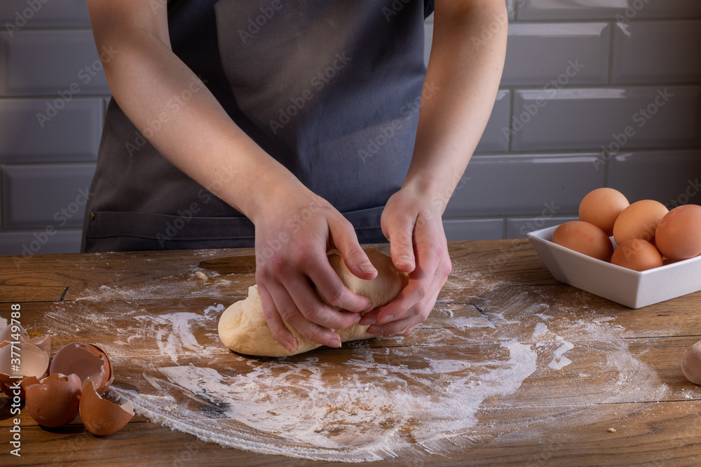 The chef's hands are kneading the dough for dumplings, pasta, bread, or pizza. Cooking dumplings – step by step guide.