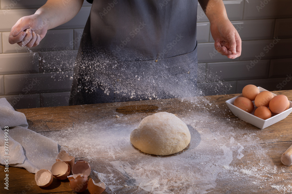 Obraz premium Chef preparing a portion of fresh dough. Cooking dumplings – step by step guide.