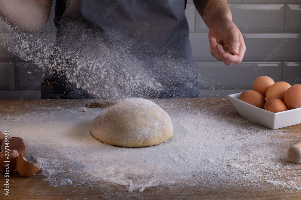 Obraz premium Chef preparing a portion of fresh dough. Cooking dumplings – step by step guide.