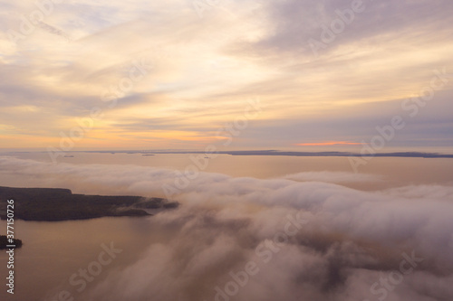 Aerial view fog and clouds over the forest and sea . View from drone. Aerial top view fog over coastline. Texture of clouds. View seashore from above.