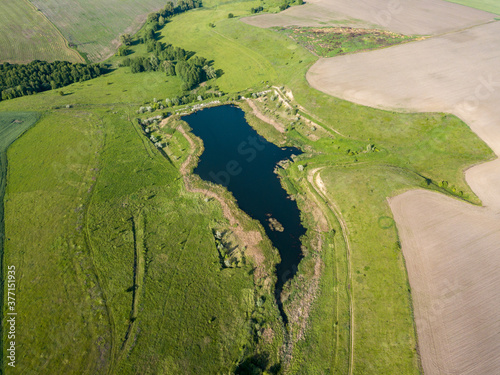 Lake among agricultural fields. Aerial drone view. © Sergey