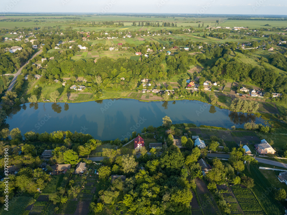 Aerial drone view. Country lake. Green grass on the shore.