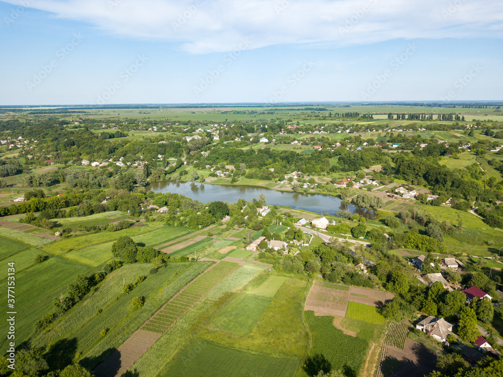 Lake among agricultural fields. Aerial drone view.