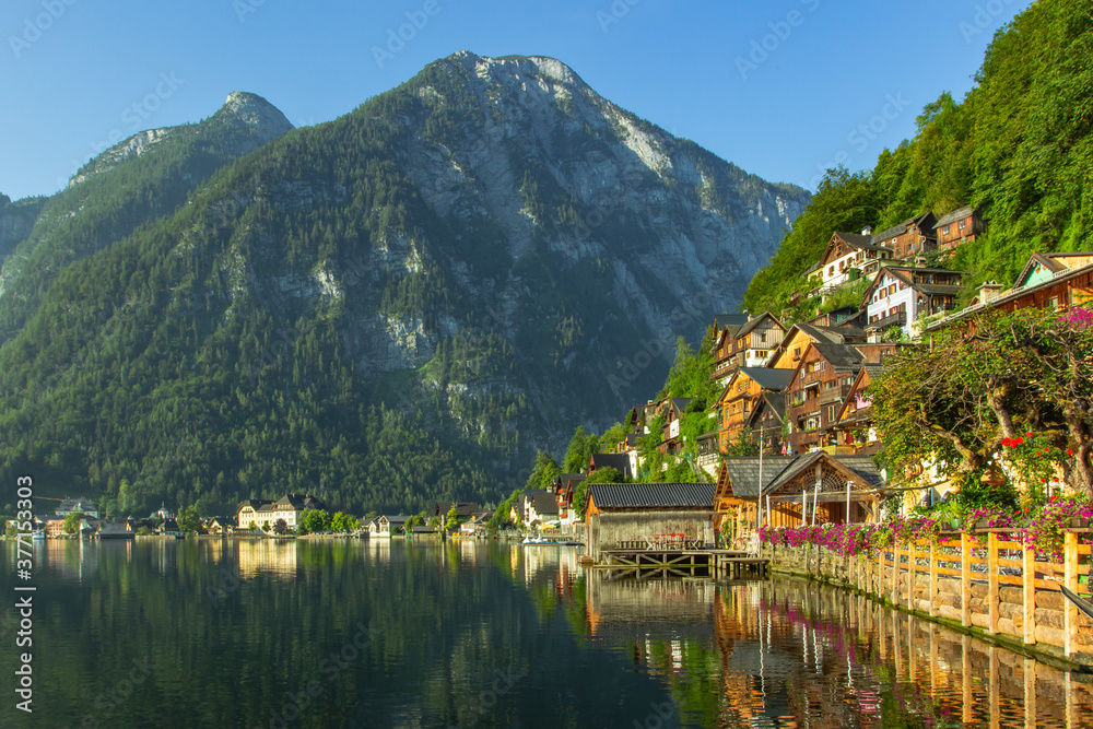 Fototapeta premium Classic postcard view of famous Hallstatt lakeside town, Austria. Scenic panoramic view of beautiful town reflecting in Hallstatter See.Beautiful sunny day in summer, Salzkammergut region.Urban scene
