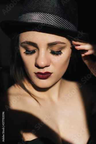 sensual portrait of young girl in black hat with red lipstick
