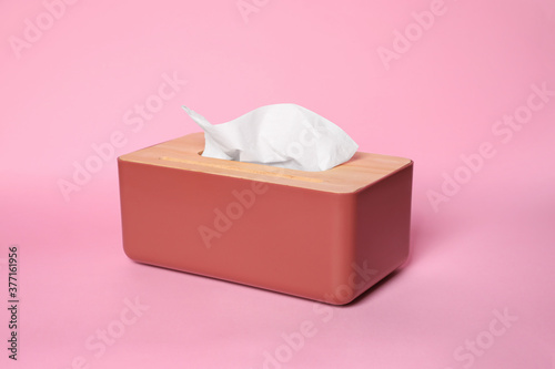 Holder with paper tissues on pink background