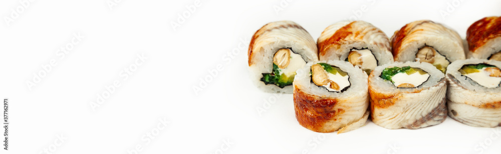 Sushi roll with eel and chuka salad on a white plate, classic Japanese sushi. Traditional Japanese food with maki. Delicious pieces of sushi. For the restaurant menu. copyspace Sushi roll with eel and chuka salad on a white plate, classic Japanese sushi. Traditional Japanese food with maki. Delicious pieces of sushi. For the restaurant menu. copyspace